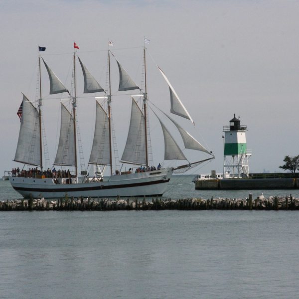 The Tall Ship Windy sailing on Lake Michigan with lighthouse in background
